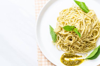Spagetti pesto sos, zeytin yağı ve fesleğen yaprakları ile.