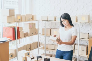 Asya kadın iş sahibi çalışan evde ambalaj kutusu ile w