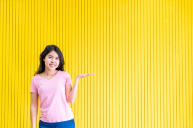 sarı duvar üzerinde ayakta Genç Asyalı kadın mutluluk