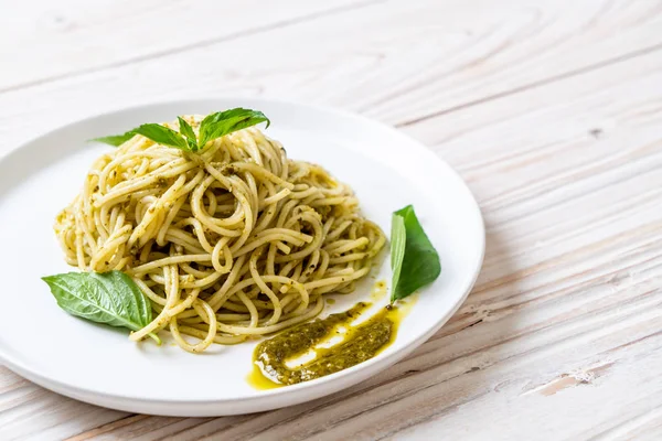 Spaghetti with pesto sauce, olive oil and basil leaves. — Stock Photo, Image