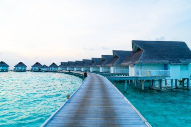 Su bungal ile Maldivler Adası üzerinde güzel tropikal günbatımı