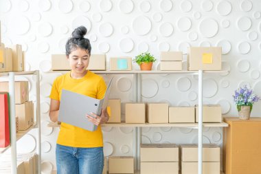  Genç Asyalı kadın ambar stok raf üzerinde mal kontrol