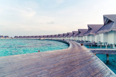 Su bungal ile Maldivler Adası üzerinde güzel tropikal günbatımı