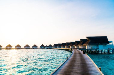 Su bungal ile Maldivler Adası üzerinde güzel tropikal günbatımı
