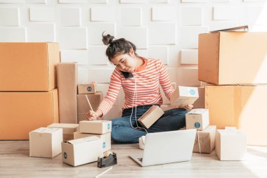 Asya kadın iş sahibi çalışan evde ambalaj kutusu ile w