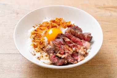 yumurta ile tepesinde pirinç kase dilimlenmiş sığır eti