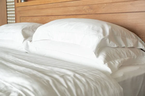 Белая подушка на декоре кровати в спальне отеля — стоковое фото