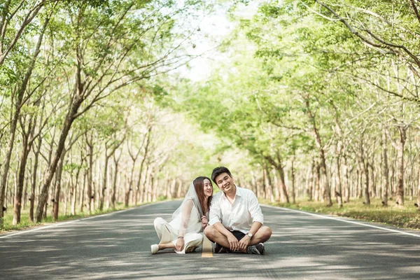 Gelukkige Aziatische paar verliefd op weg met boom boog — Stockfoto