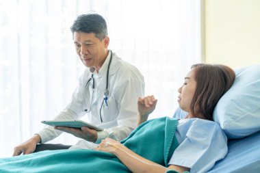 Hastane yatağı üzerinde oturan ve ile tartışırken Asya kıdemli doktor 