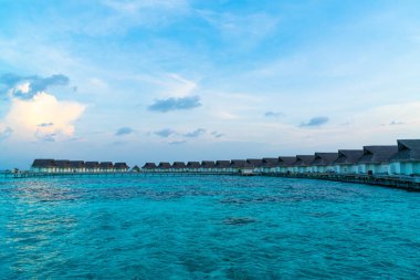 Su bungal ile Maldivler Adası üzerinde güzel tropikal günbatımı