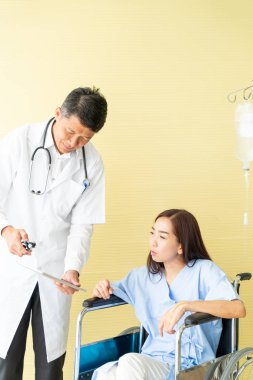 tekerlekli sandalye ile kıdemli doktor kadın hastayı