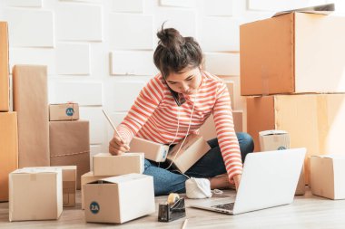 Asya kadın iş sahibi çalışan evde ambalaj kutusu ile w