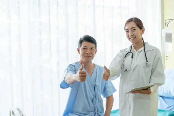 Asiático paciente sênior na cama do hospital discutir com doct fêmea — Fotografia de Stock