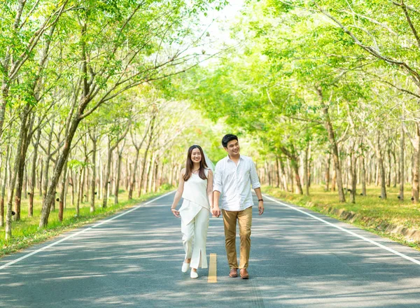 Gelukkige Aziatische paar verliefd op weg met boom boog — Stockfoto