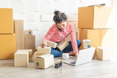 Asya kadın iş sahibi çalışan evde ambalaj kutusu ile w