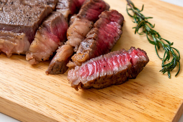 Grilled medium rare beef steak on wood board