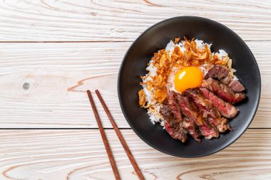 yumurta ile tepesinde pirinç kase dilimlenmiş sığır eti