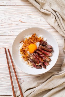 yumurta ile tepesinde pirinç kase dilimlenmiş sığır eti