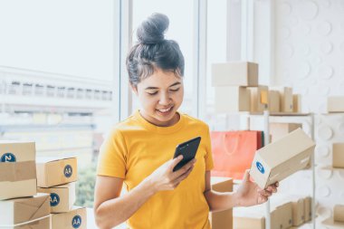 Asya kadın iş sahibi çalışan evde ambalaj kutusu ile w