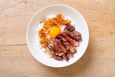 yumurta ile tepesinde pirinç kase dilimlenmiş sığır eti