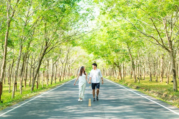 Gelukkige Aziatische paar verliefd op weg met boom boog — Stockfoto