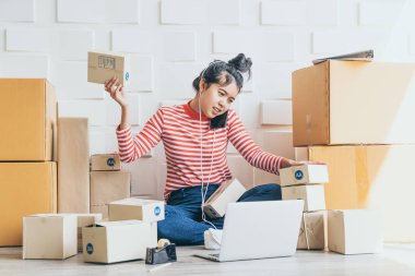 Asya kadın iş sahibi çalışan evde ambalaj kutusu ile w