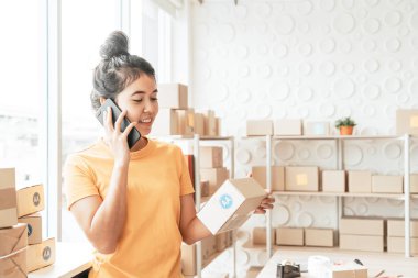 Asya kadın iş sahibi çalışan evde ambalaj kutusu ile w