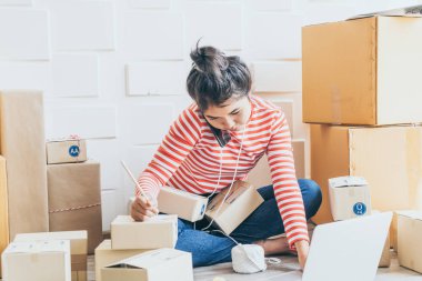 Asya kadın iş sahibi çalışan evde ambalaj kutusu ile w