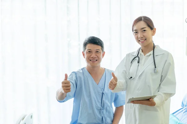 Asiatique senior patient sur lit d'hôpital discuter avec femelle doct Images De Stock Libres De Droits