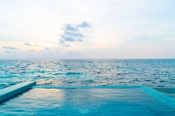 Okyanus Denizi ve günbatımı gökyüzü arka plan ile açık yüzme havuzu — Stok fotoğraf