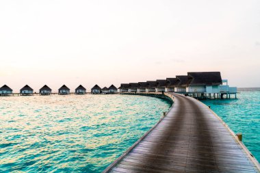 Su bungal ile Maldivler Adası üzerinde güzel tropikal günbatımı