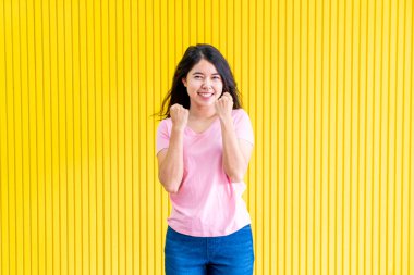 sarı duvar üzerinde ayakta Genç Asyalı kadın mutluluk