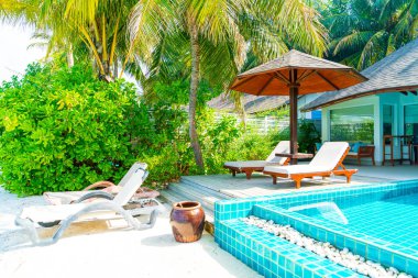 Maldivler yüzme havuzu ve deniz arka plan ile plaj sandalyesi