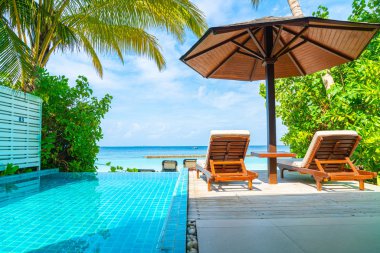 Maldivler yüzme havuzu ve deniz arka plan ile plaj sandalyesi