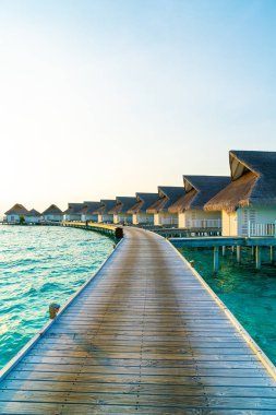 Su bungal ile Maldivler Adası üzerinde güzel tropikal günbatımı
