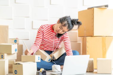 Asya kadın iş sahibi çalışan evde ambalaj kutusu ile w