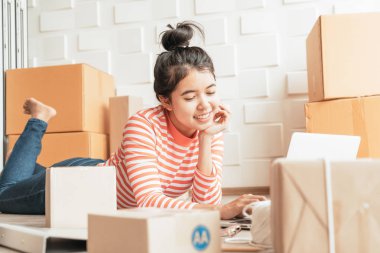 Asya kadın iş sahibi çalışan evde ambalaj kutusu ile w