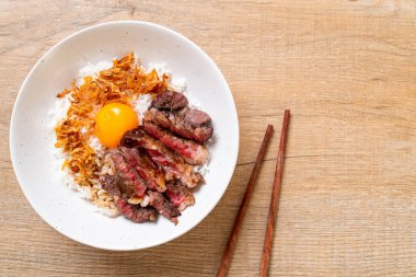 yumurta ile tepesinde pirinç kase dilimlenmiş sığır eti