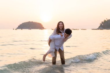 Mutlu çift balayı gidiş tropikal kum plajı üzerinde su içinde seyahat.