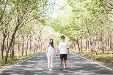 Ağaç arch ile yolda aşık mutlu Asya çift