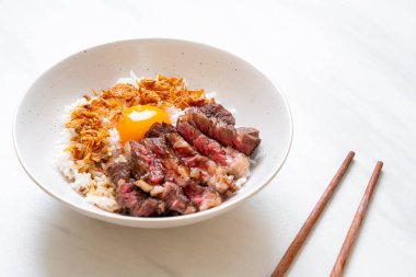 yumurta ile tepesinde pirinç kase dilimlenmiş sığır eti