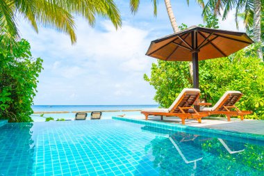 Maldivler yüzme havuzu ve deniz arka plan ile plaj sandalyesi
