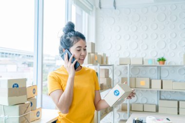 Asya kadın iş sahibi çalışan evde ambalaj kutusu ile w