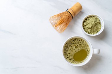 Yeşil çay tozu ve çırpılmış sıcak kibrit yeşil çay fincanı.