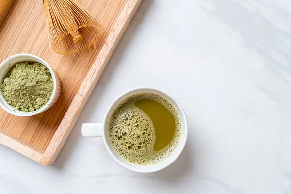 hot matcha green tea cup with green tea powder and whisk