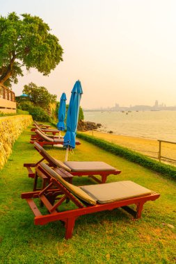 Pattaya, Tayland 'da günbatımında deniz manzaralı plaj sandalyesi.