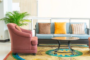 Boş kanepe ve yastıklı sandalye bir odada.