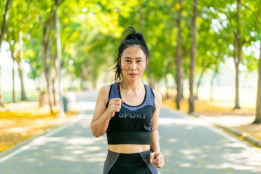 Parkta koşan Asyalı kadın.