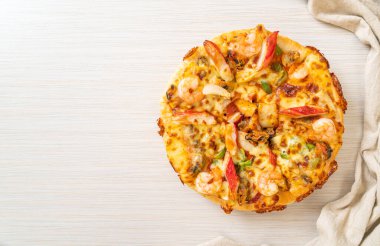 Tahta tepside deniz ürünleri (karides, ahtapot, midye ve yengeç) pizza