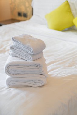 Otel odasında beyaz havlu katlanır.